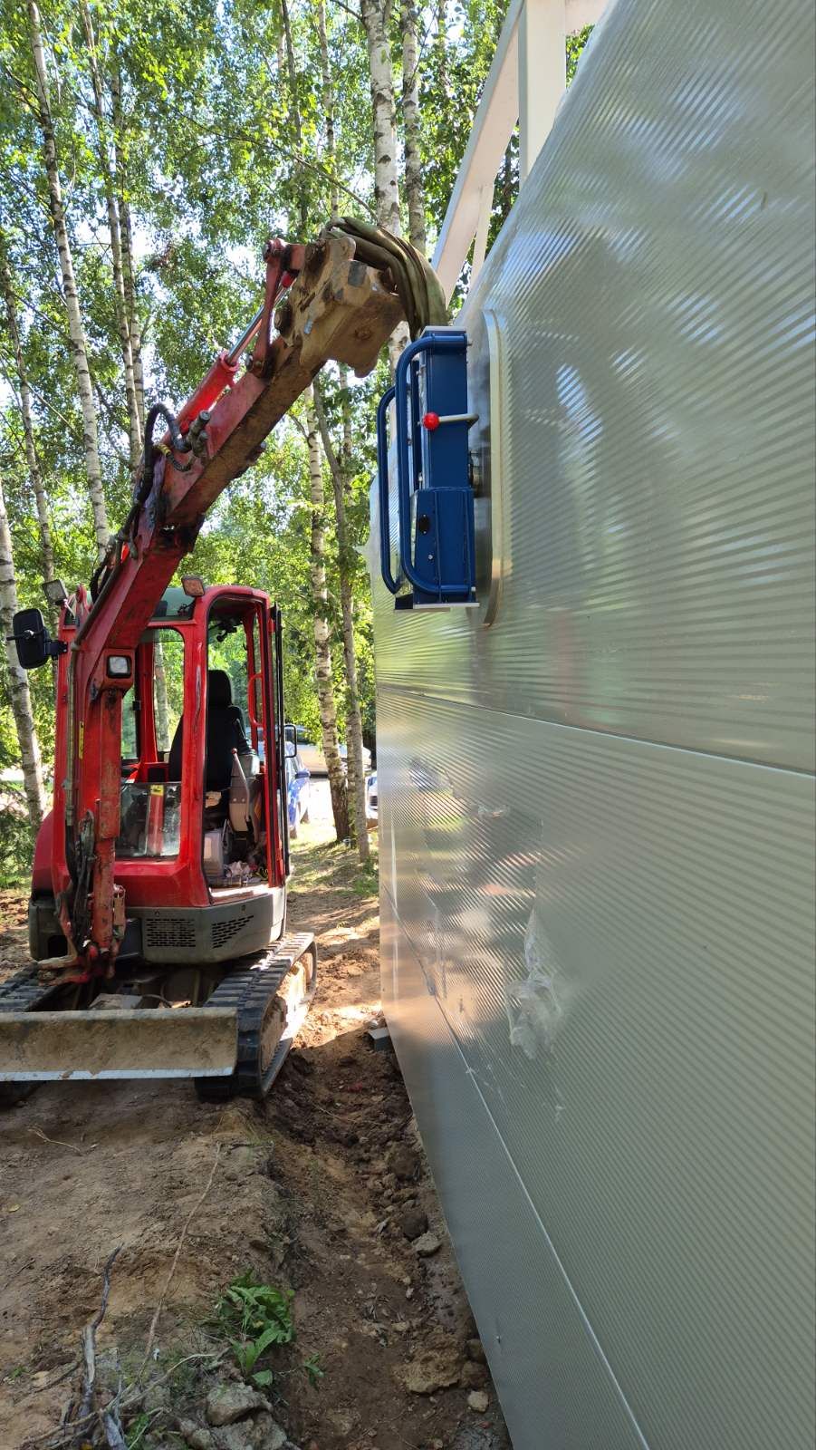 Ekskavatorius su vakuuminiu keltuvu montuoja sieninę sandwich plokštę